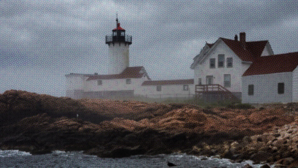White lighthouse and keeper's house on the rocky shore